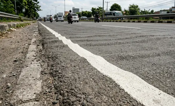 striping jalan aspal yang bergelombang karena kerusakan aspal jalan
