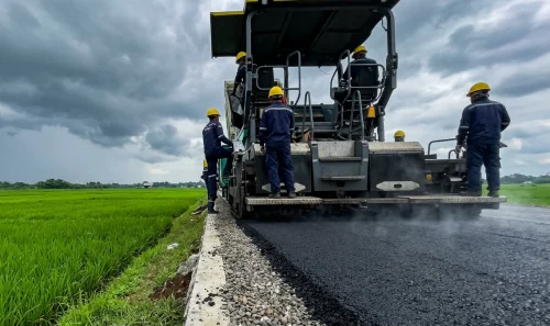 Proyek pengaspalan jalan di area persawahan Purwakarta oleh PT. Aspalindo Karya Nusantara menggunakan mesin asphalt finisher modern
